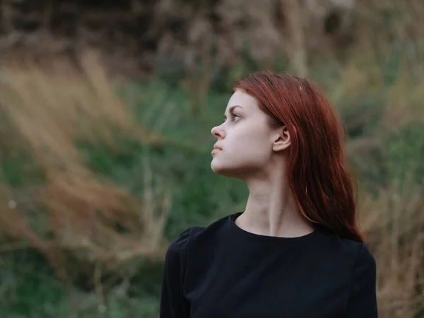 Portrait d'une femme en robe noire à l'extérieur sur une prairie dans les montagnes — Photo