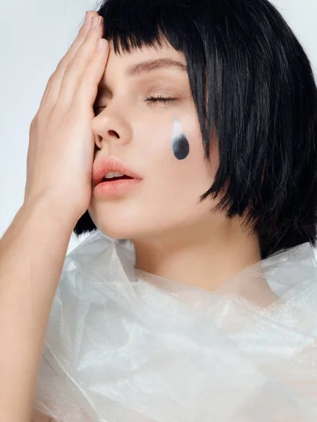 Mulher com cabelo preto e um adesivo no rosto cachecol transparente e olhos fechados — Fotografia de Stock