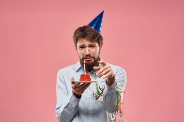 Pastalı ve pembe arka planda mumu olan bir adamın doğum günü. Yüksek kalite fotoğraf