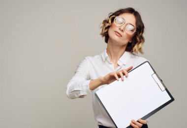 Kadın, beyaz kağıt gözlüklü klasörü ve saç stili modelini gösteriyor