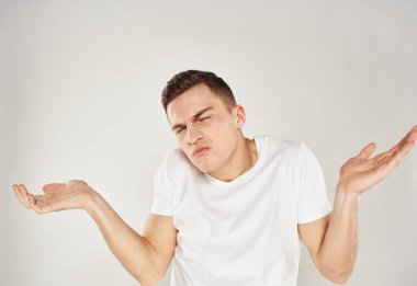 Şaşırmış bir adam arka planda hafif bir açıyla ellerini yana açıyor.