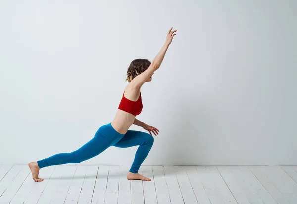 Sportig kvinna i ett ljust rum och gör yoga asana övningar — Stockfoto
