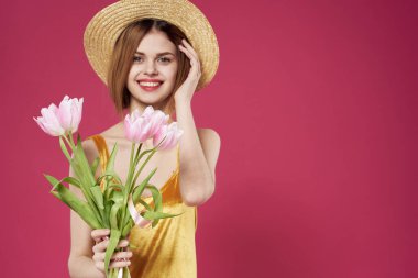 Altın elbiseli kadın çiçek buketi hediye olarak pembe arka plan