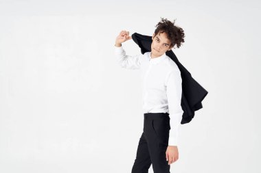 Kıvırcık saçlı, ceketli bir iş adamı. 