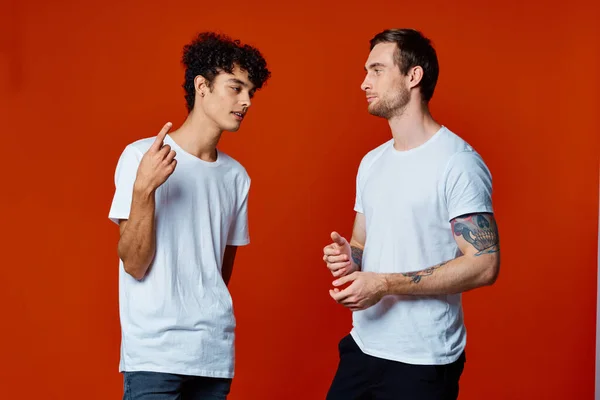 Due amici allegri in bianco t-shirt stare fianco a fianco isolato sfondo — Foto Stock