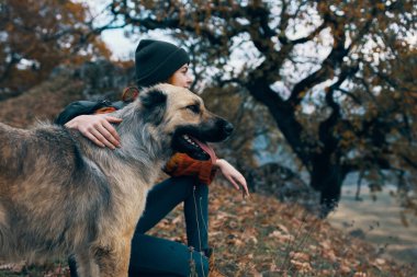 Neşeli kadın yürüyüşçü köpek kucaklayan açık hava gezisi arkadaşlığı