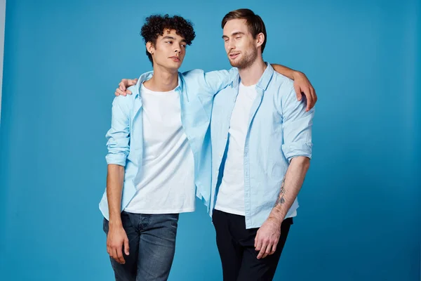 Migliori amici che si abbracciano su sfondo blu in corrispondenza t-shirt vista ritagliata — Foto Stock