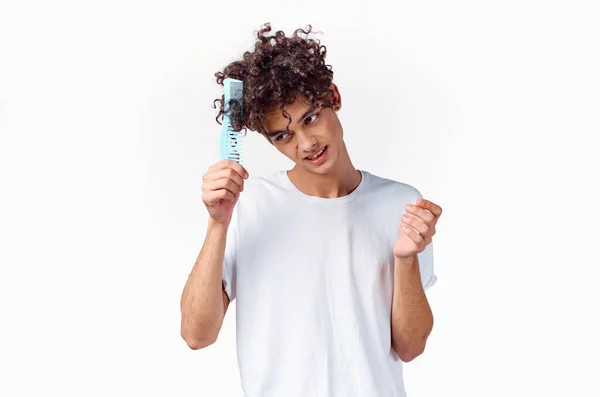 Homem alegre em uma camiseta branca pente cabelo cachos emoções — Fotografia de Stock