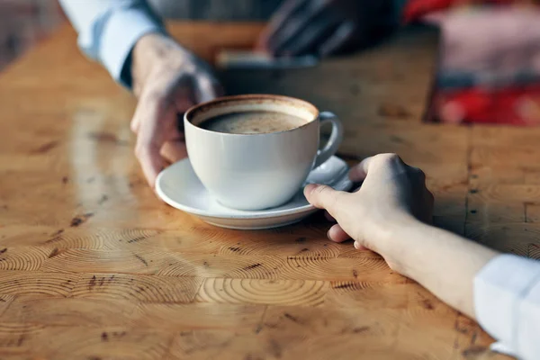 Le chef sert au client une tasse de café avec une soucoupe sur la table et une boisson au restaurant — Photo