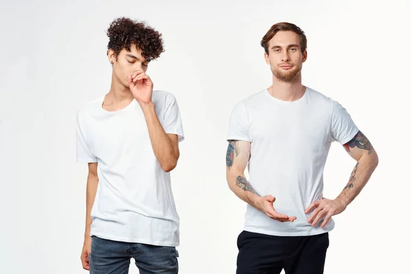 Due uomini in bianco t-shirt stand fianco a fianco ritagliato vista studio — Foto Stock