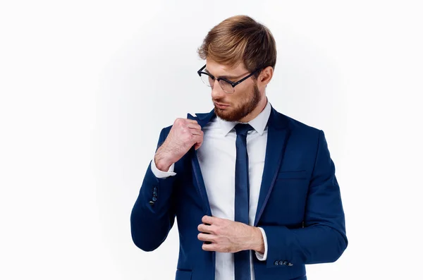 Um homem loiro de óculos e em um terno clássico endireita sua gravata em torno de seu pescoço e jaqueta — Fotografia de Stock