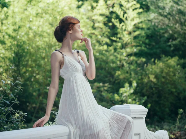 Aantrekkelijke vrouw in witte jurk frisse lucht groene bladeren — Stockfoto