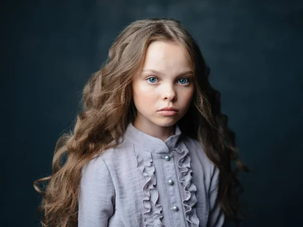 Piękne mało dziewczyna smutne twarz ciemne tło i szary strój portret — Zdjęcie stockowe