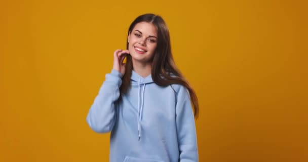 Beautiful girl posing in front of the camera on a pink background and smiling — Stock Video