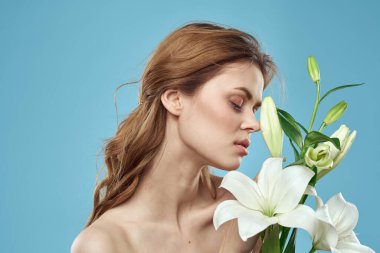 Mavi arka planda beyaz çiçekli bir kız. Kızıl saç portresi modeli.