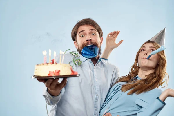 Érzelmi férfi tortával és csinos nő party disco kék háttér — Stock Fotó