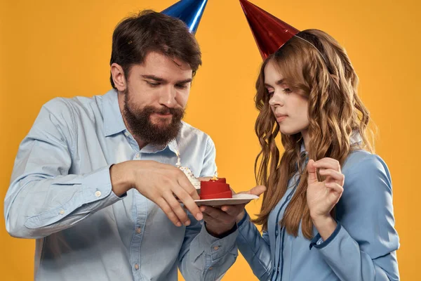 Doğum günü partisi erkeği ve kadın eğlence sarı arka plan şapka tatili — Stok fotoğraf