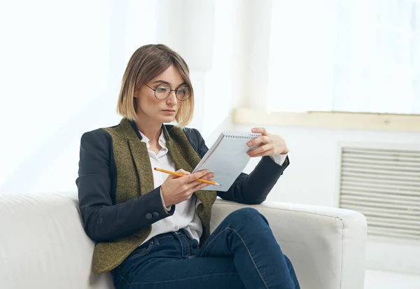 Zakelijke vrouw met een map van documenten en in een klassiek pak binnenshuis in de buurt van het raam — Stockfoto