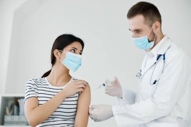 Erkek doktor aşıyı omuz sağlığı koronavirüsüne enjekte ediyor.