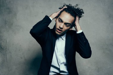 Siyah ceketli kıvırcık saçlı adam poz veriyor. Yüksek kalite fotoğraf