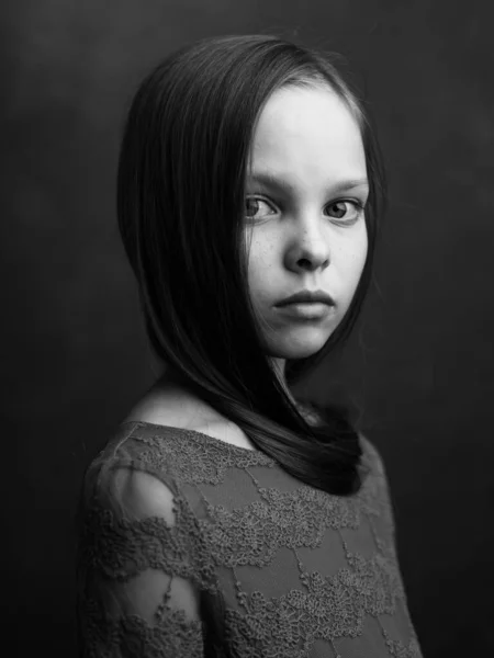 Potret seorang gadis kecil dengan latar belakang gelap model gaun dipotong pandangan hitam dan putih fotografi — Stok Foto
