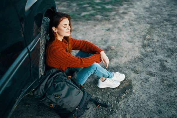 traveler in the mountains near the car resting in nature