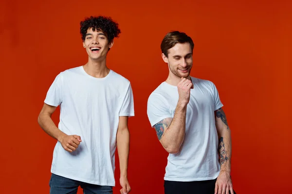 Два веселых мужчины на футболках общения дружбы красный фон — стоковое фото