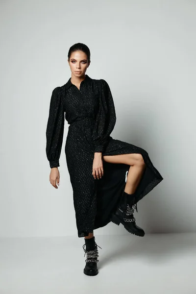 Γυναίκα σε μαύρο φόρεμα λυγισμένο γόνατο μόδα ελκυστική εμφάνιση — Φωτογραφία Αρχείου