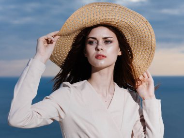 Hasır Şapkalı ve açık renk elbiseli kadın okyanustaydı. 