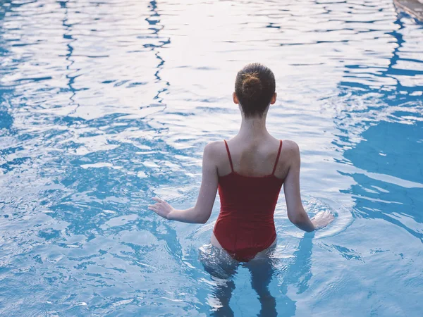 Mulher sexy em maiô vermelho fica cintura profunda na piscina transparente vista superior da água — Fotografia de Stock