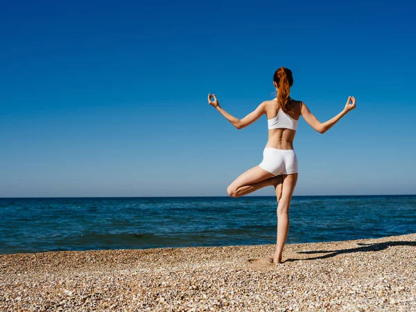 Donna in costume da bagno bianco movimento allenamento sulla spiaggia vacanza estiva meditazione — Foto Stock