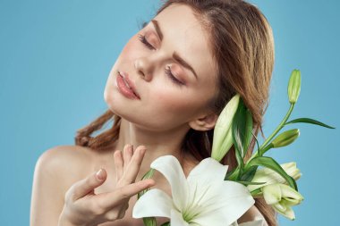 Mavi arka planda beyaz çiçekli bir kız. Kızıl saç portresi modeli.