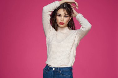 Güzel esmer, uzun saçlı, şık, zarif, pembe arka planlı.