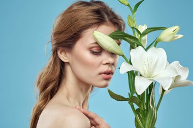 Mavi arka planda beyaz çiçekli bir kız. Kızıl saç portresi modeli.