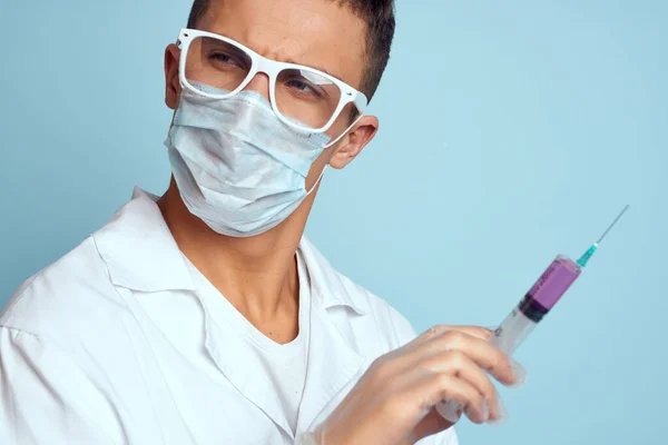 Muž lékař bílý kabát léčba lékařské nástroje modré pozadí — Stock fotografie