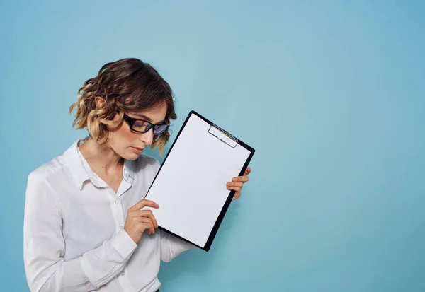 Femme d'affaires dans un costume et des lunettes avec un dossier de documents dans ses mains et une feuille blanche de papier — Photo