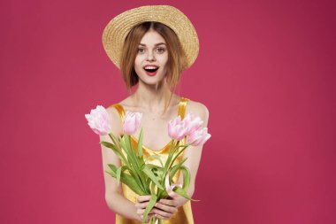 Altın elbiseli kadın çiçek buketi hediye olarak pembe arka plan