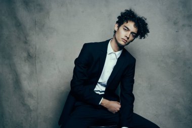 Takım elbiseli iş adamı kendine güvenen kıvırcık saçlı moda stüdyosu