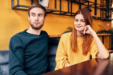 Bir kafede, bir kadın ve erkek arkadaş ilişkilerinin olduğu masada.