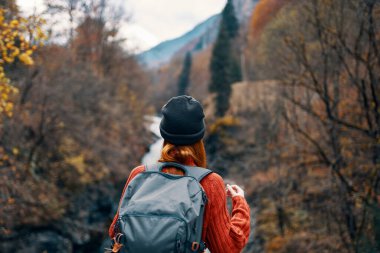 Sırt çantasıyla dağlara seyahat eden bir kadın.