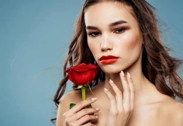 Jeune femme avec rose rouge près du visage ombre sur paupières bleu modèle de fond — Photo