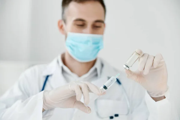 Лікар у медичній масці тримає шприц у руці вакцина проти хімічної рідини — стокове фото