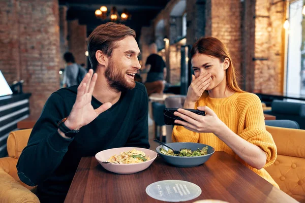 Słodkie mężczyźni i kobiety w a restauracja z a telefon w ich ręce selfie — Zdjęcie stockowe