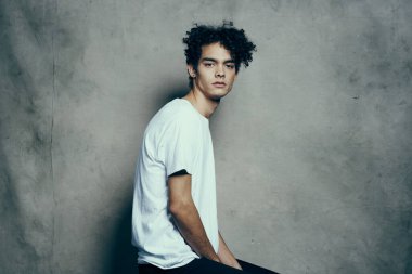 Kıvırcık saçlı ve gözlüklü mutlu adam. Model fotoğraf stüdyosu duyguları.