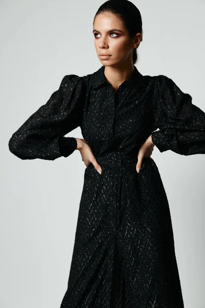 Kvinna i svart klänning ser åt sidan mode charm — Stockfoto
