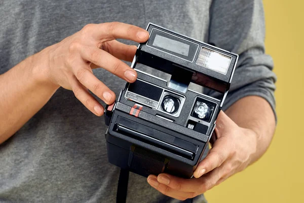 Appareil photo dans les mains d'un homme photographe fond jaune professionnel — Photo