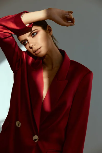 Mulher atraente com maquiagem brilhante olha para a jaqueta vermelha lateral — Fotografia de Stock