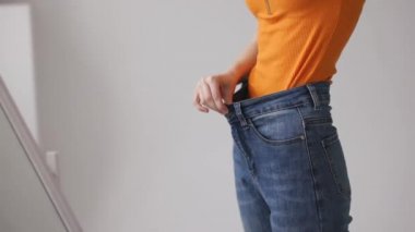 Bir kadın aynaya bakar ve kilosunu, kilosunu ve kilosunu ölçer.