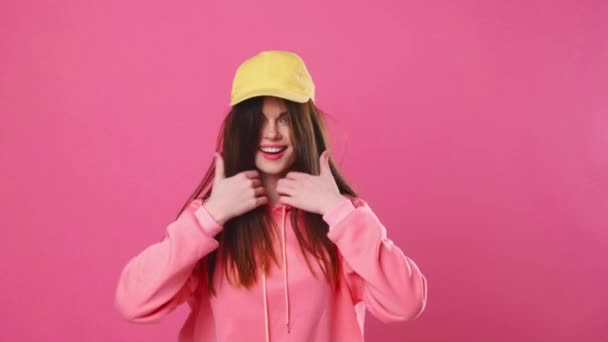 Ung vacker kvinna i gul mössa poserar framför kameran — Stockvideo