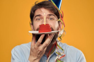 Sarı arka planda, tabakta pasta olan bir adam.